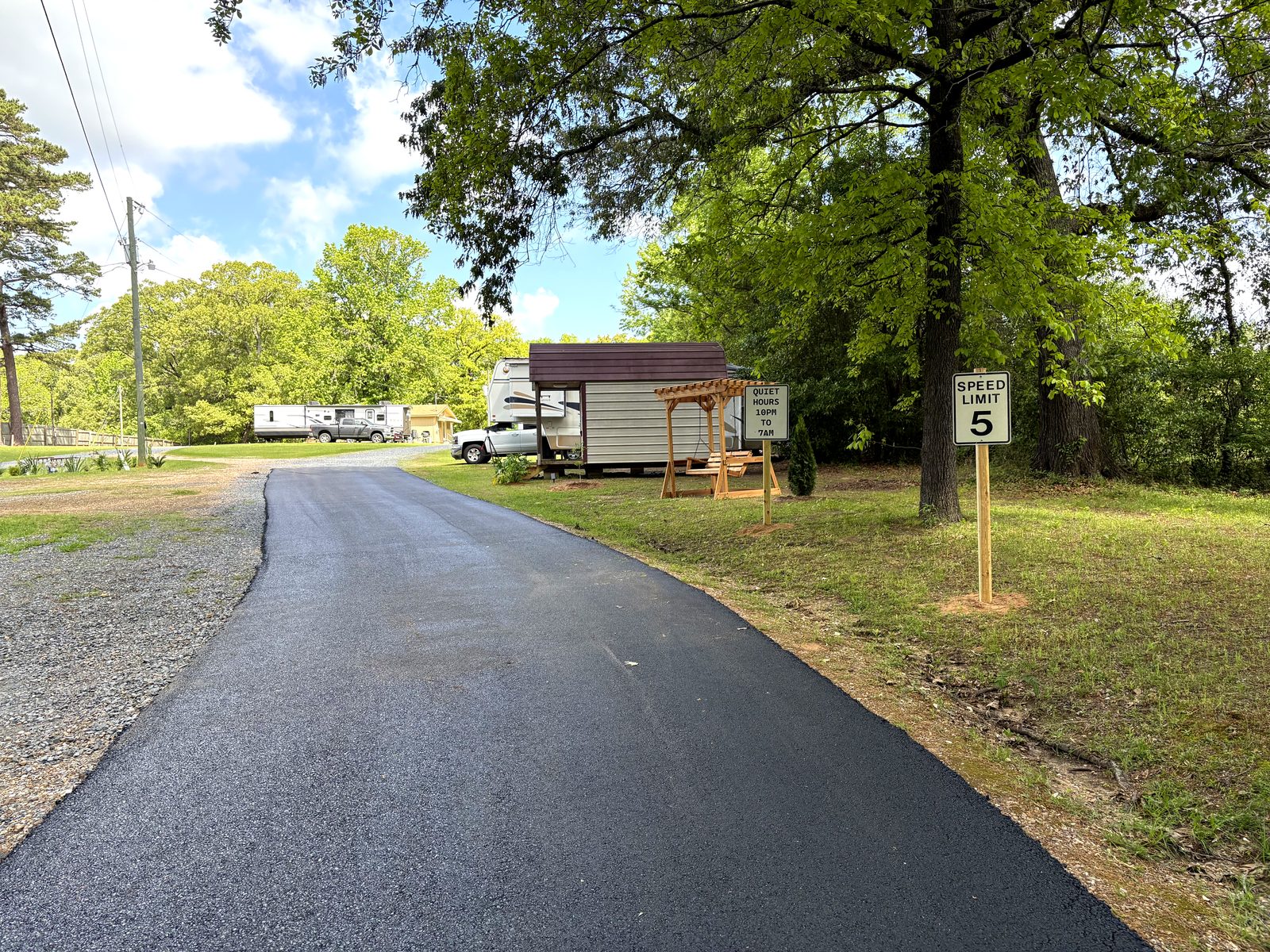 Paved road with RVs parked in shaded sites at Dogwood Ridge RV Park Natchitoches Louisiana